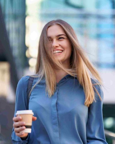 woman-in-motion-with-coffee-outdoors-ZEJNGRK.jpg